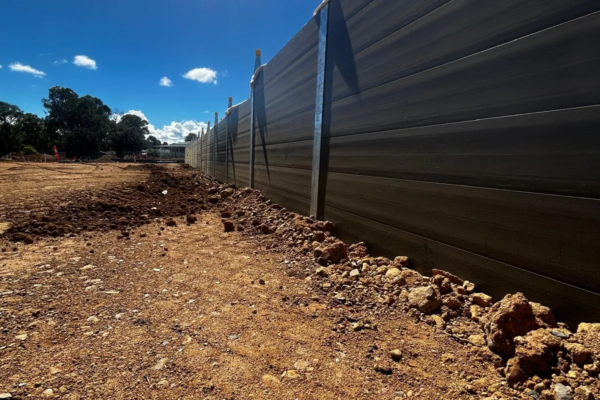 Long charcoal SuperSleeper retaining wall under construction