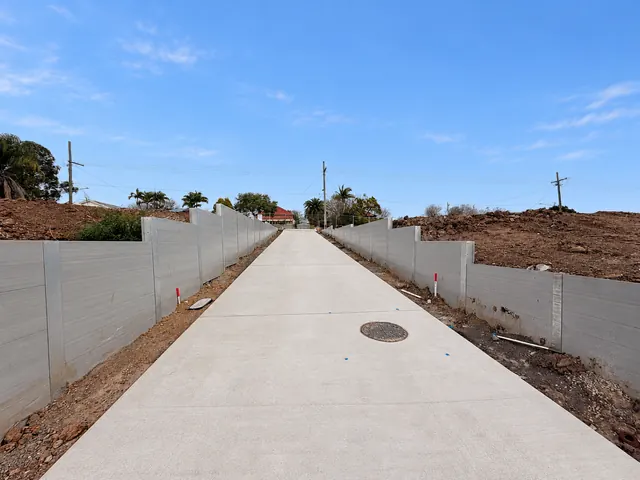 Concrete access path between grey sleeper retaining walls on a civil project