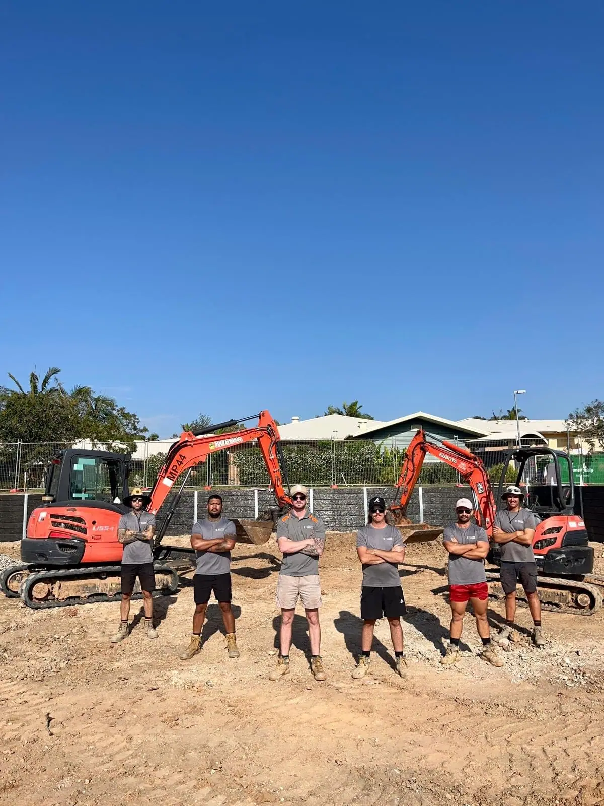 Elite Walls crew and excavators on a commercial retaining wall site
