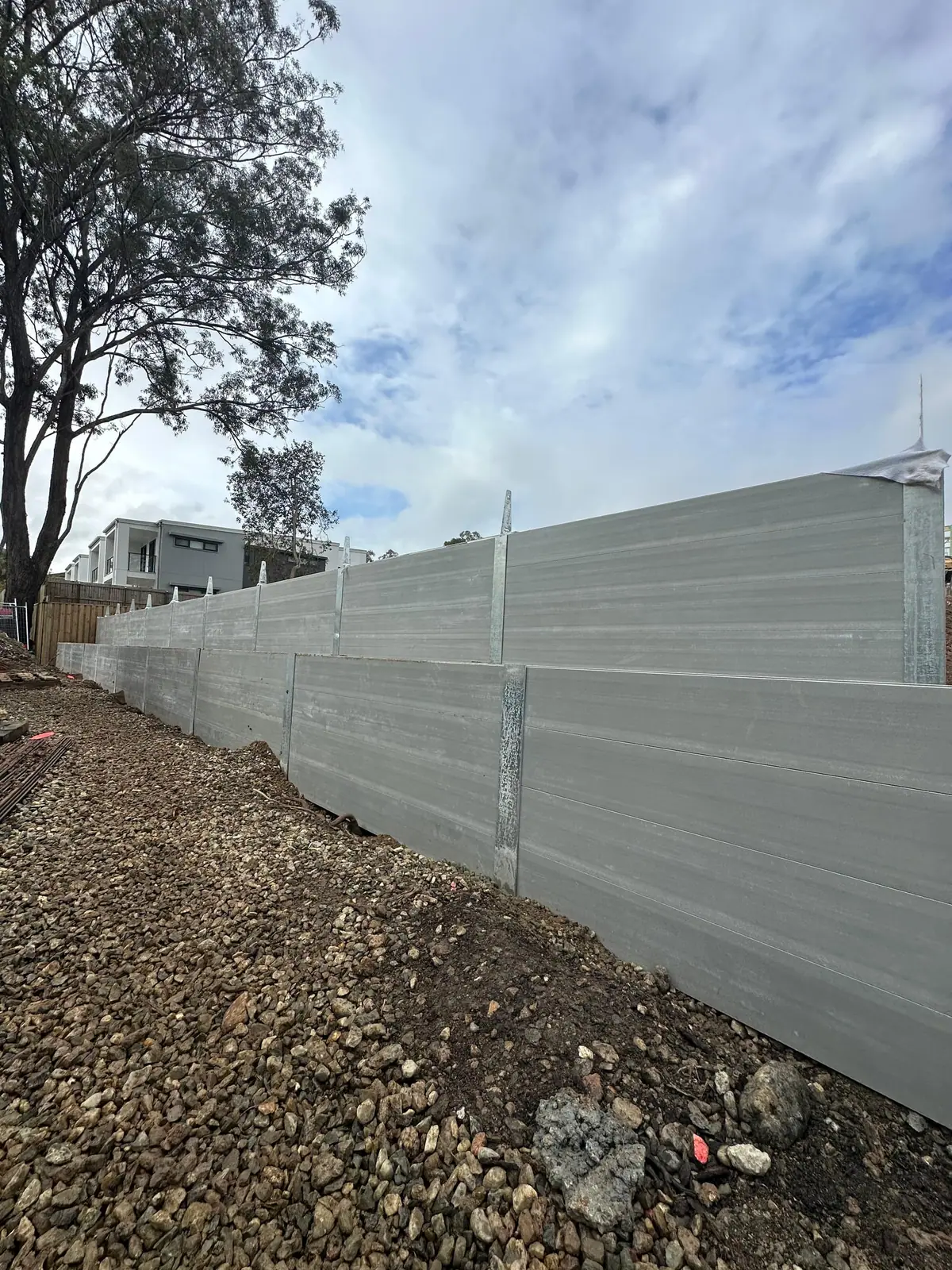 Long grey concrete sleeper retaining wall on a commercial site