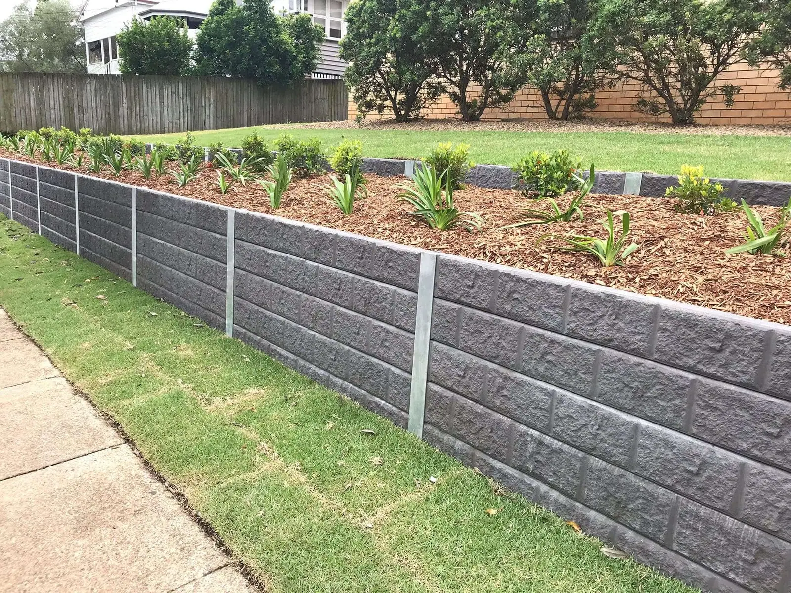 Landscaped residential concrete sleeper retaining wall