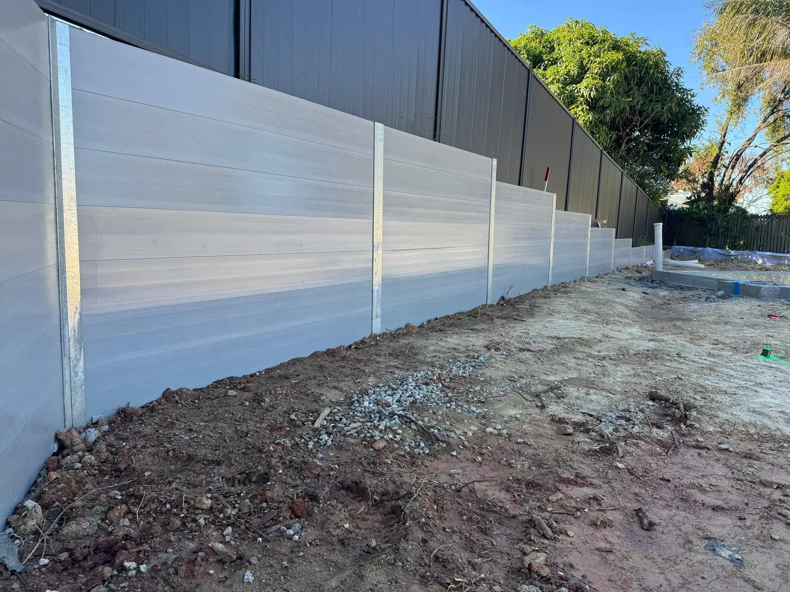 Long light concrete sleeper wall on a residential block