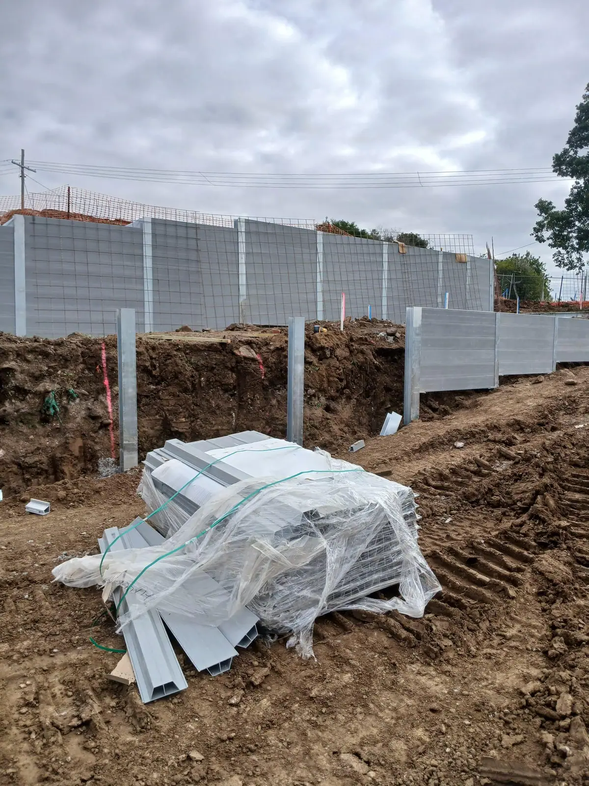 SuperSleeper retaining wall installation with posts and panels ready on site