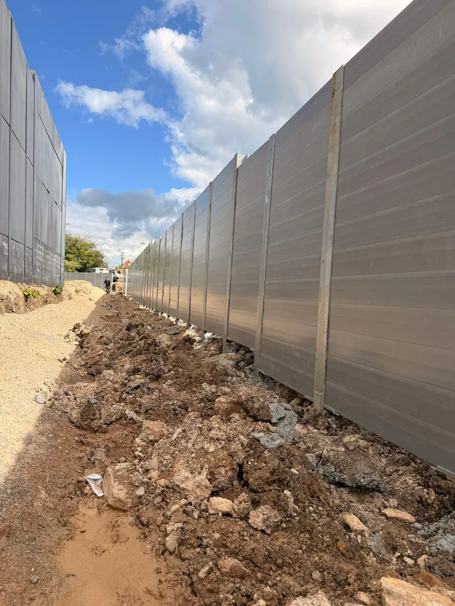 Long grey concrete sleeper retaining wall during commercial earthworks