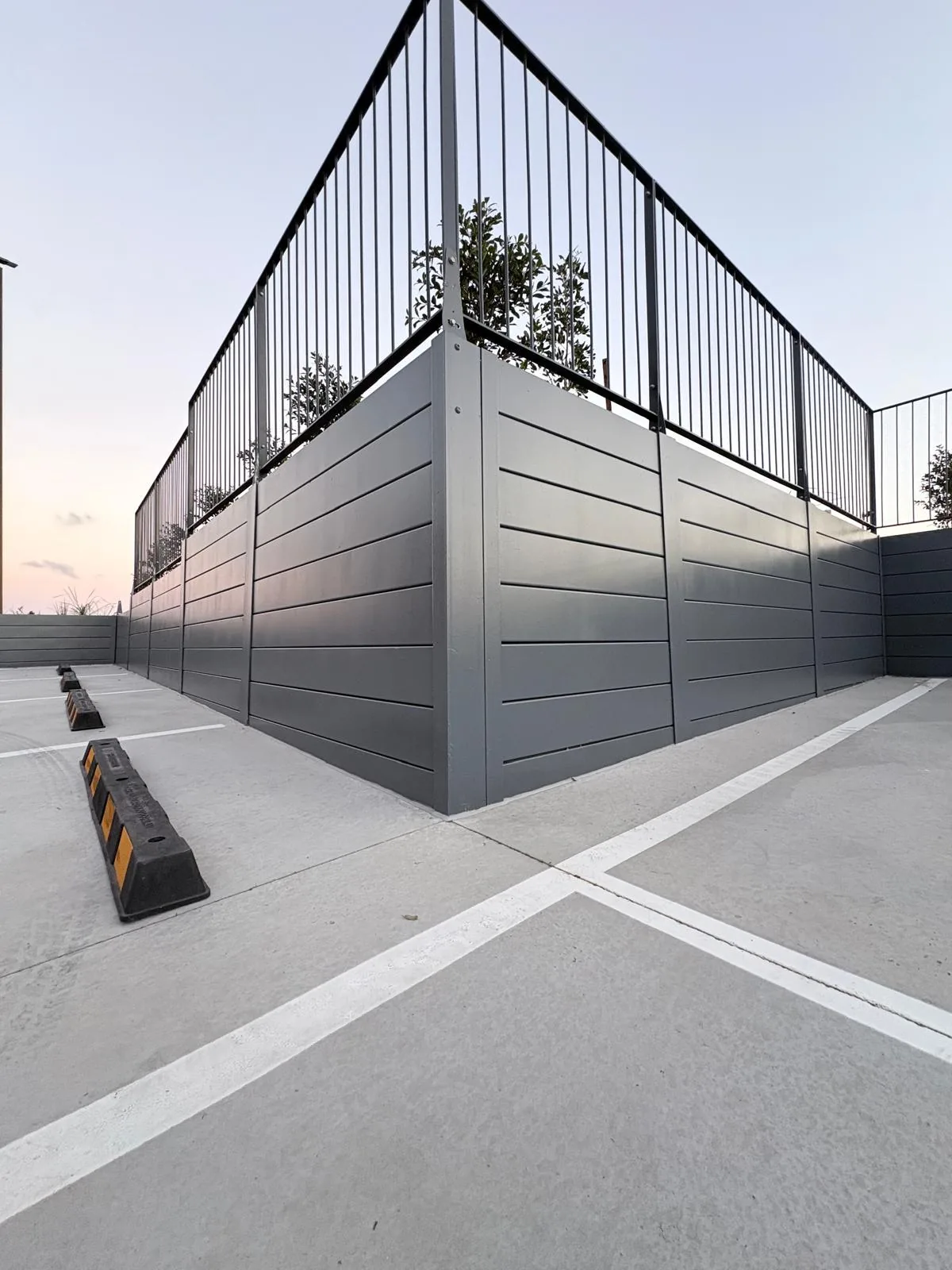 Engineered retaining wall and balustrade beside a commercial car park