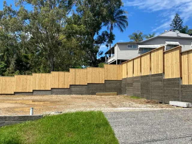 Stepped timber fencing and sleeper walls following a sloping front yard