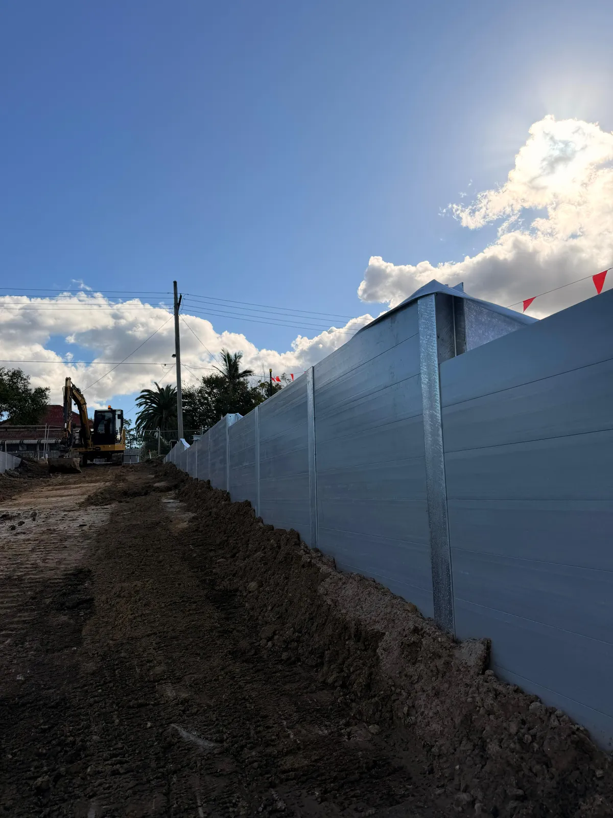 Tall SuperSleeper wall with an excavator on site