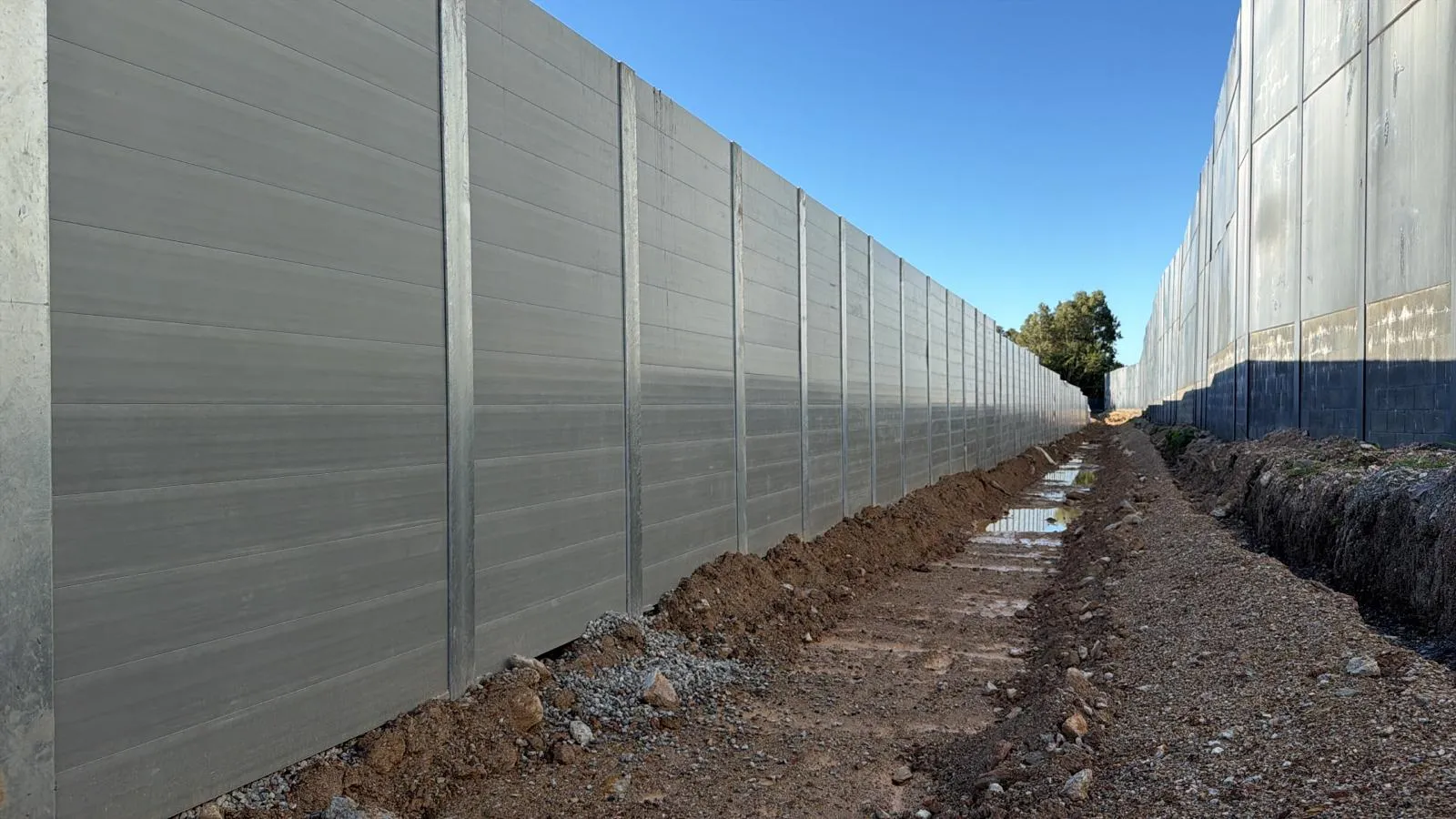 Long SuperSleeper retaining wall installation under a blue sky